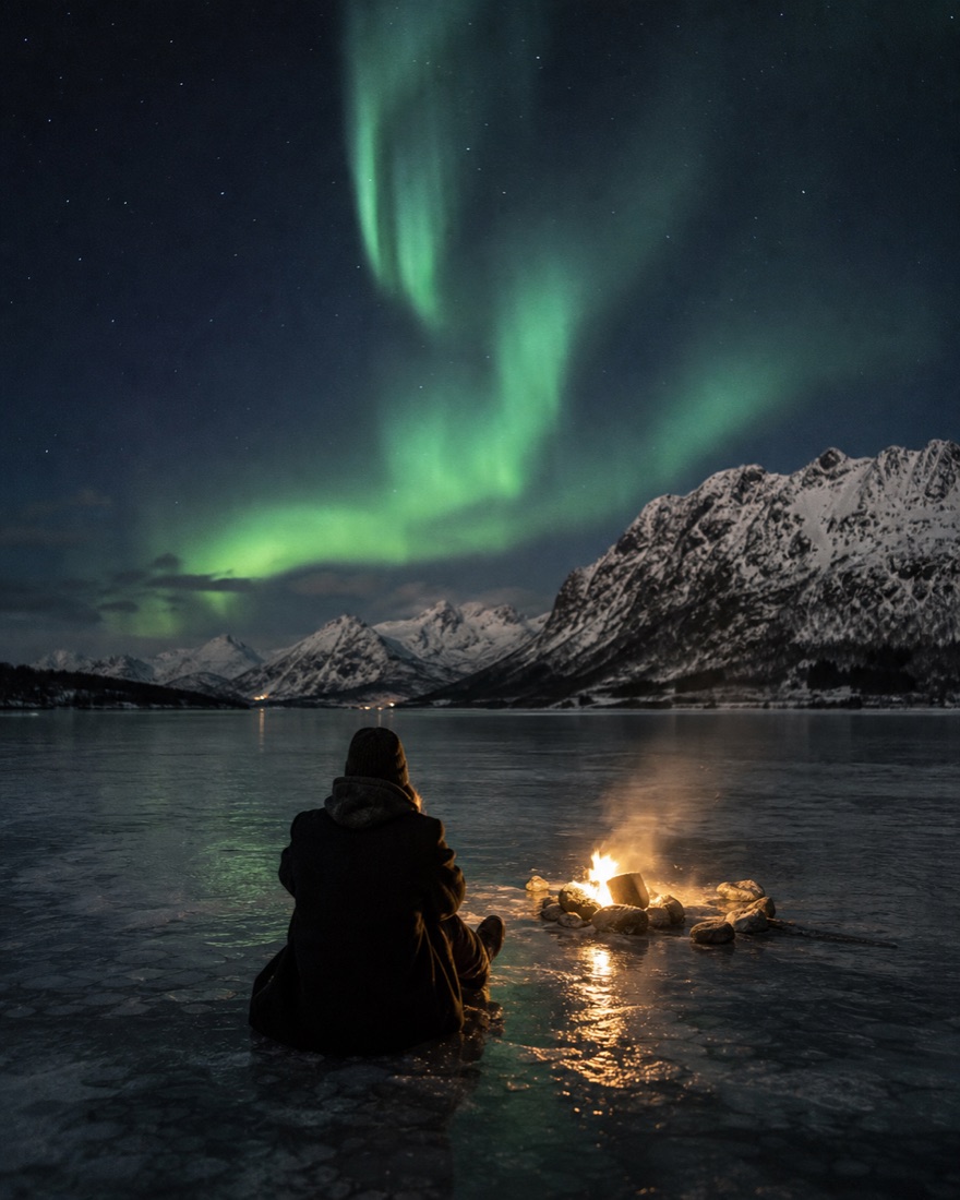 The northern lights over snowy mountains in Lofoten, Norway
