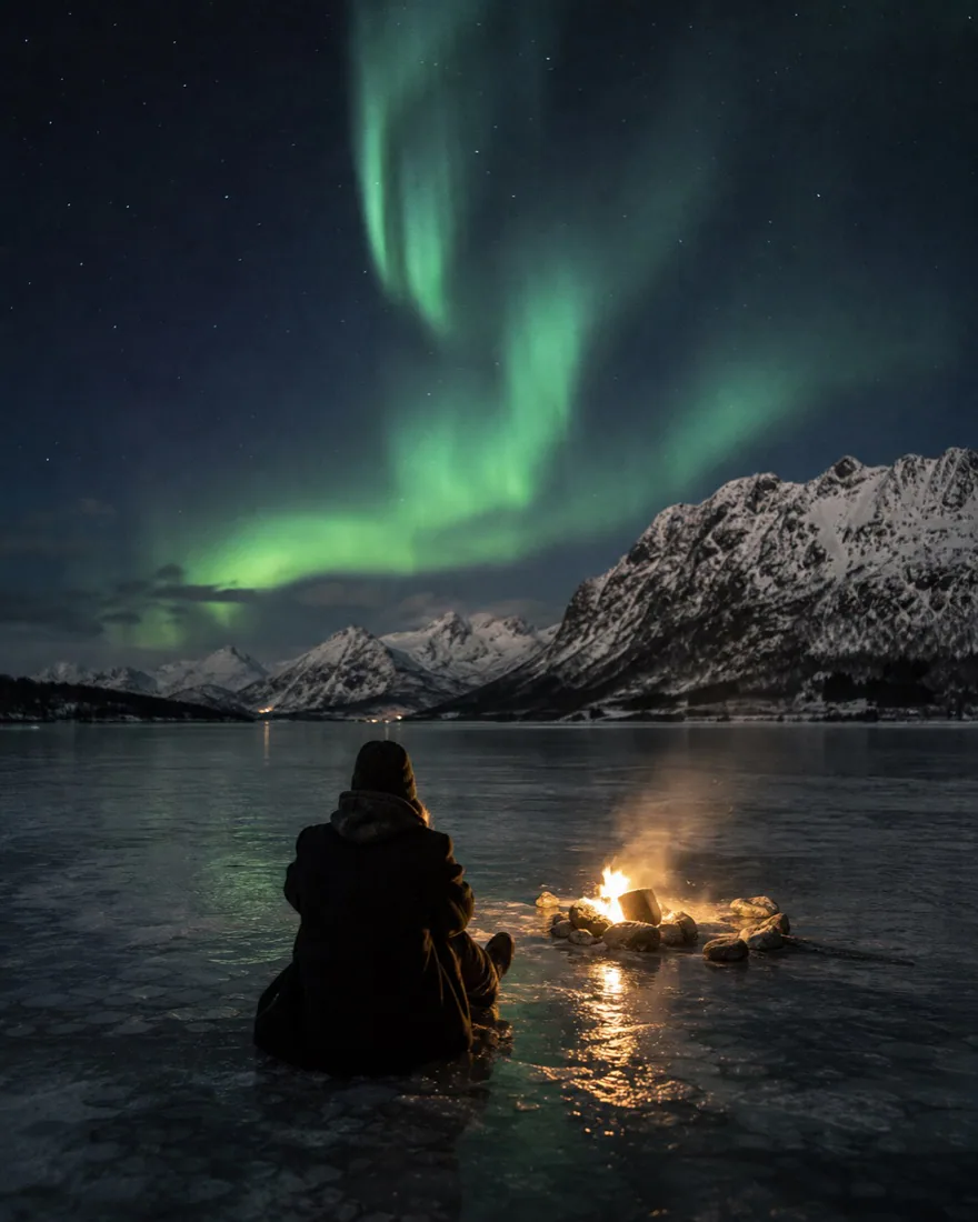 The northern lights over snowy mountains in Lofoten, Norway